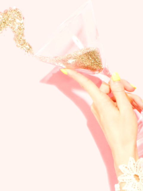 Person holding clear martini glass filled with glitter