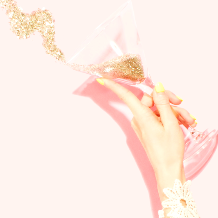 Person holding clear martini glass filled with glitter