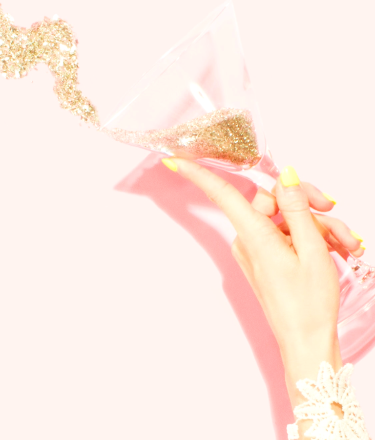 Person holding clear martini glass filled with glitter