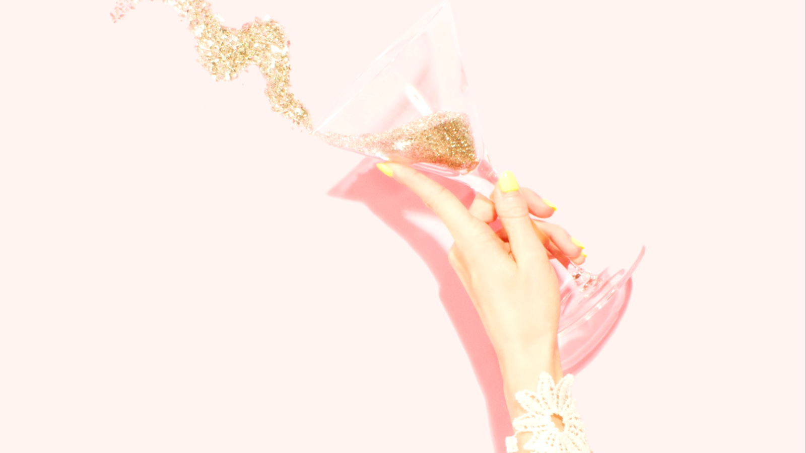 Person holding clear martini glass filled with glitter