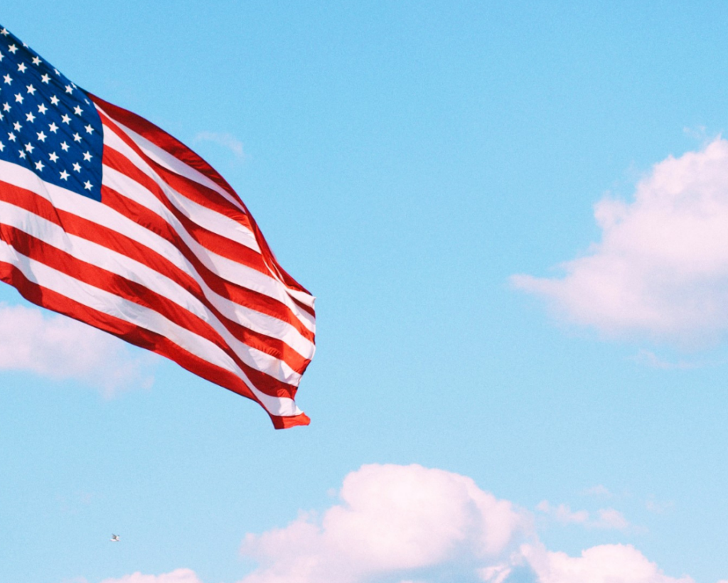Flag of U.S.A. under white clouds during daytime