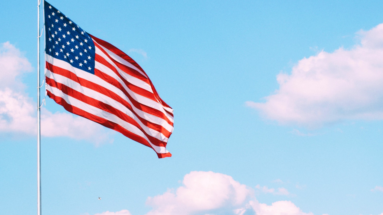 Flag of U.S.A. under white clouds during daytime
