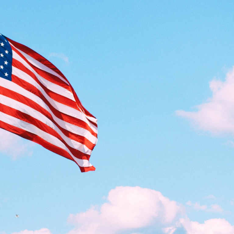 Flag of U.S.A. under white clouds during daytime