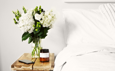 Flowers and candles next to bed