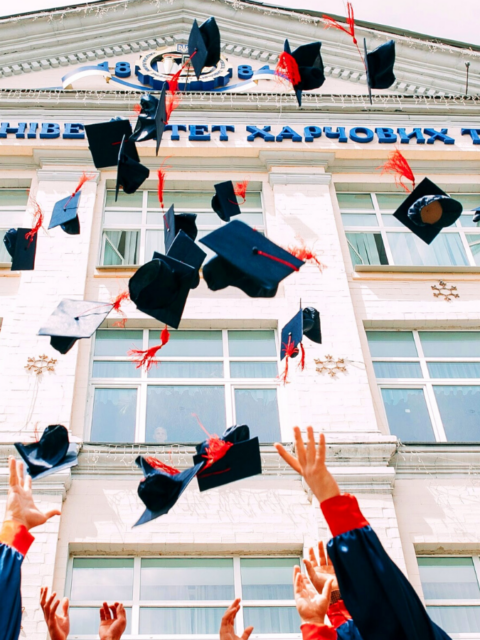 group of fresh graduates students throwing their academic hat in the air