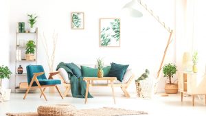 Pineapple on wood stool in living room with green furniture and braided pouf on carpet