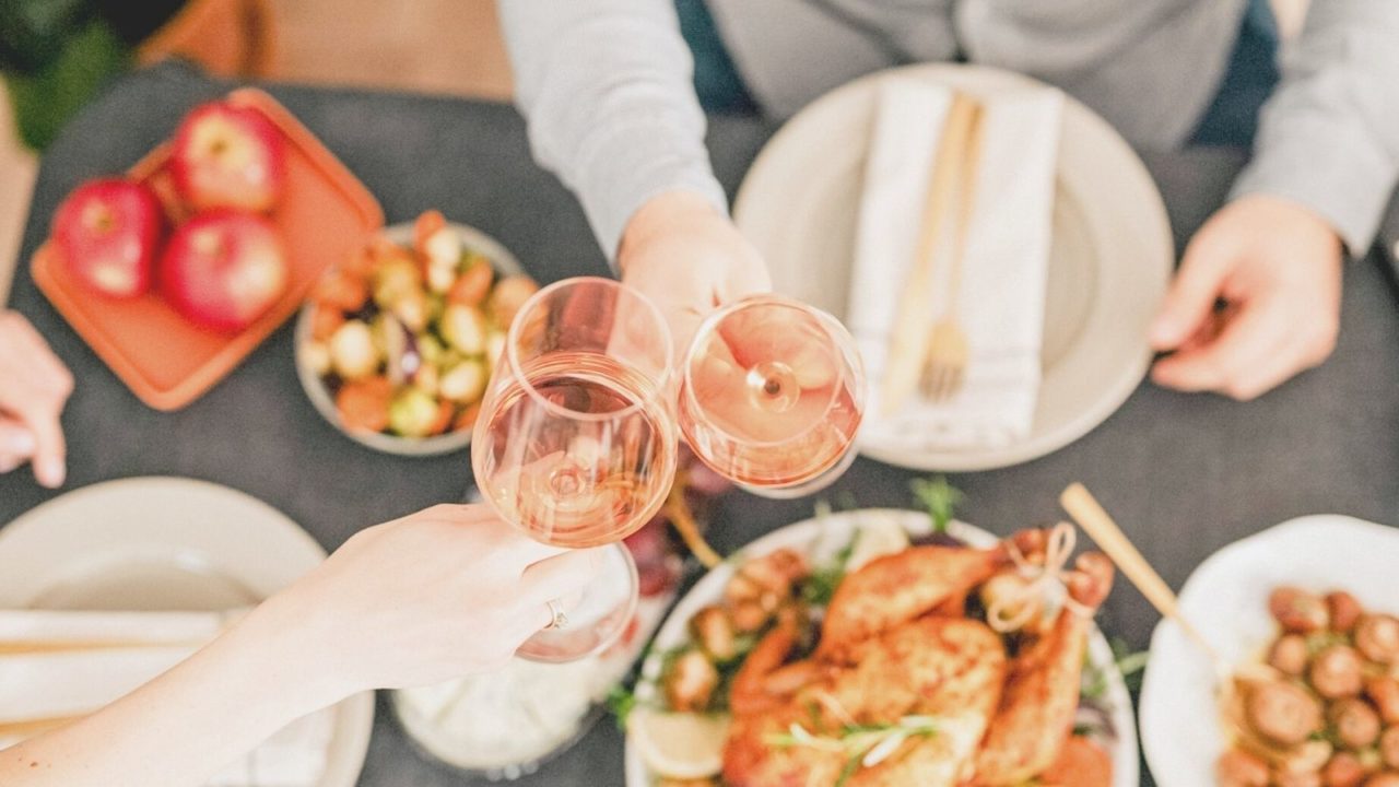 Food On The Table With Two People Having Wine